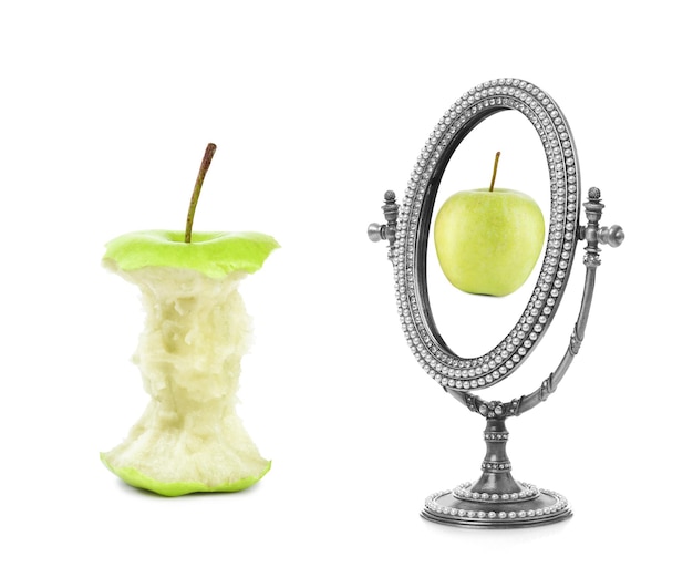 Apple core and mirror with reflection on white background