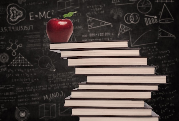 Foto simbolo dell'istruzione della mela e pila di libri in classe