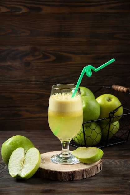 Apple fresh juice with fresh apple on wood plate dark background