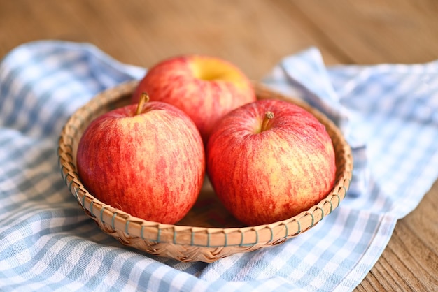 Apple fruit on basket on the wooden table ripe red apples