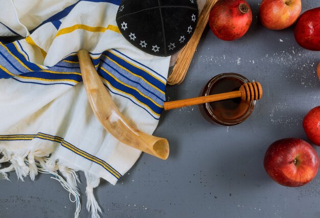 Foto apple, granaatappel en honing van het joodse nieuwjaar rosh hashana torahboek, kippah yamolka talit