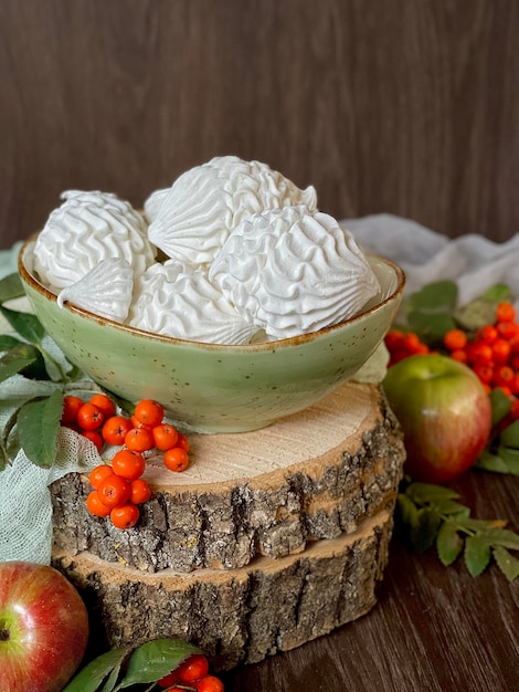 apple homemade marshmallows in a plate on wooden saw cuts, autumn concept, photo on the phone