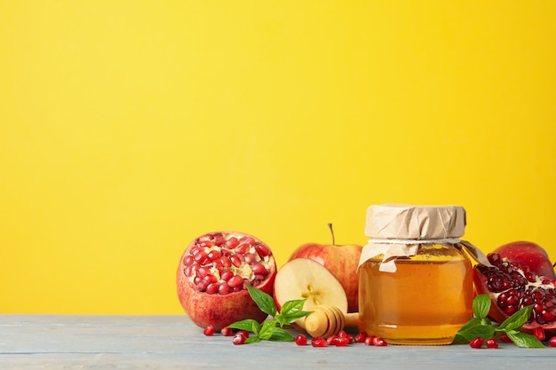 Apple, honey and pomegranate against yellow. Home treatment