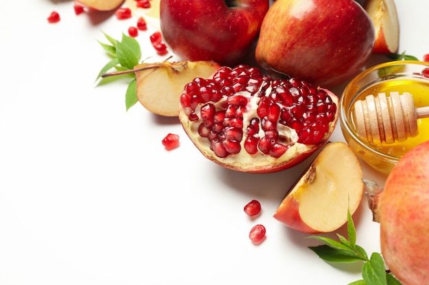 Apple, honey and pomegranate on white, close up