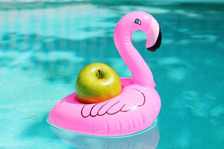 Photo apple in inflatable duck on swimming pool