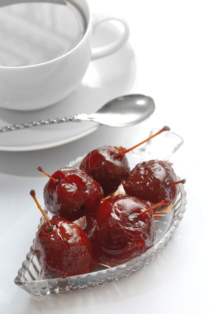 Apple jam in a bowl, a cup with a spoon on a saucer.