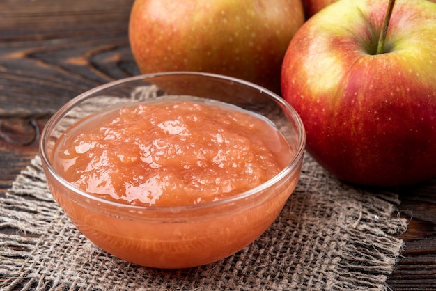 Apple jam on dark wooden background.