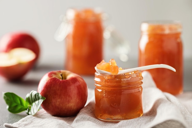 Apple jam in a glass jar. Apple jam on a light background. Delicious natural marmalade.