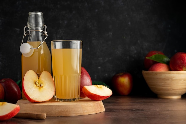 Foto bevanda di succo di mela con mele rosse fresche fondo di legno bakground scuro