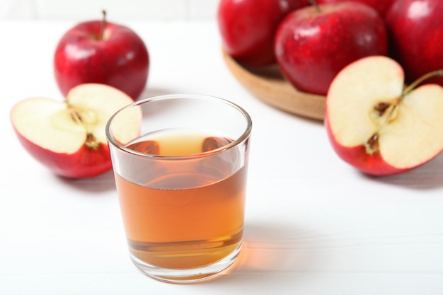 Apple juice from red apples on the table