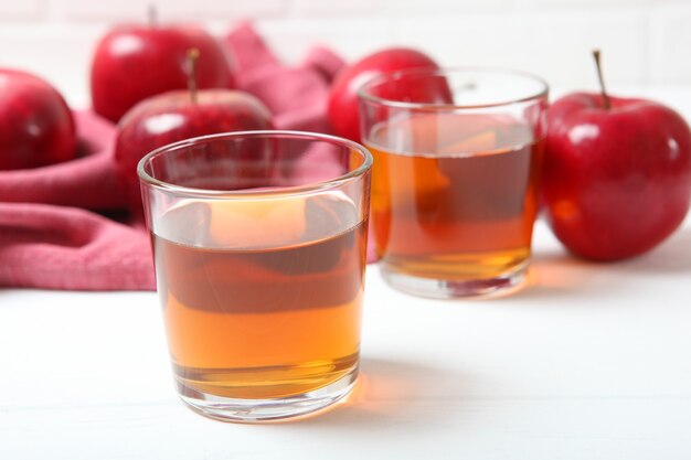 Apple juice from red apples on the table