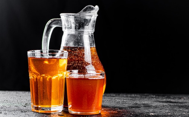 Apple juice in a jug and glasses with air bubbles