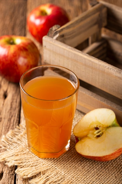 Apple juice and red apples on the table.