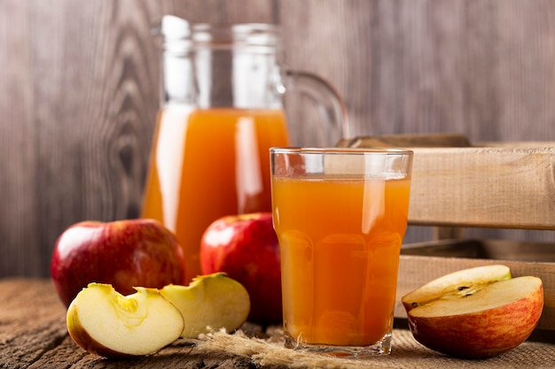 Apple juice and red apples on the table.