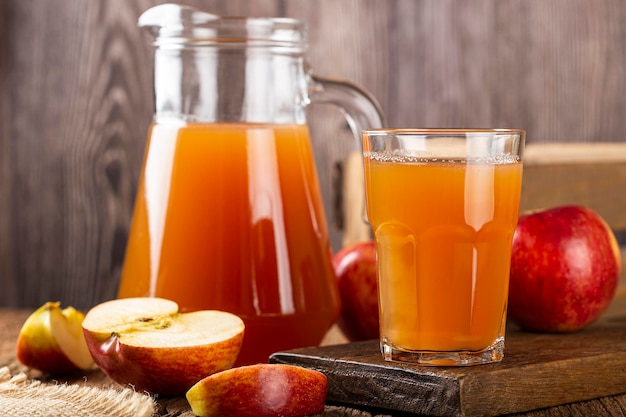 Apple juice and red apples on the table.