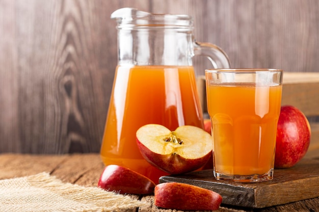 Apple juice and red apples on the table.