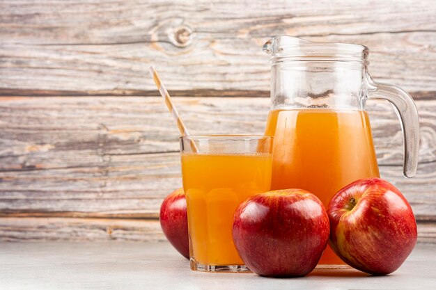 Apple juice and red apples on the table.