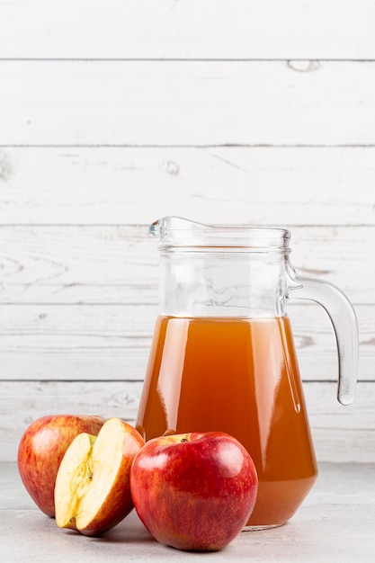 Succo di mela e mele rosse sul tavolo.