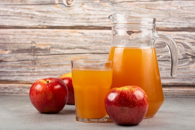 Apple juice and red apples on the table.