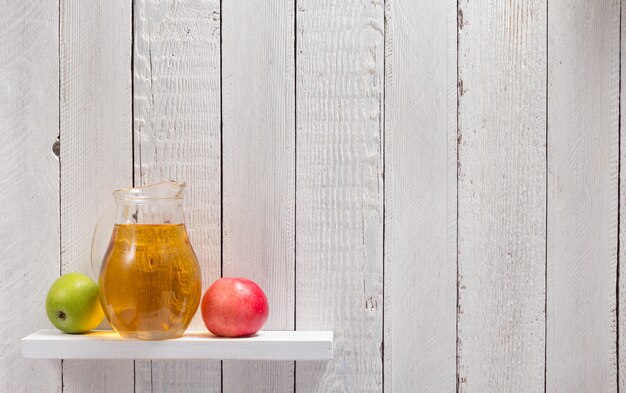 Apple juice at shelf on wooden background