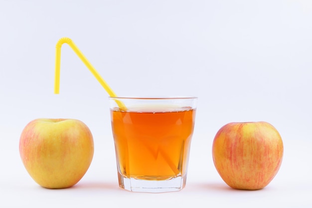 Photo apple juice with straw in glass freshly squeezed fruit juice and apple on white background healthy drink