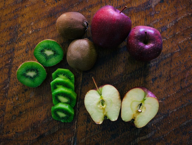 Apple and kiwi on wooden table