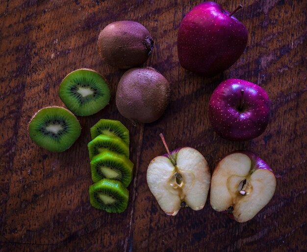 Apple and kiwi on wooden table