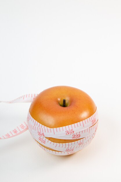 Apple & measuring tape on white background.