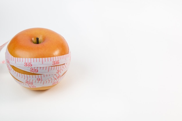 Apple & measuring tape on white background.