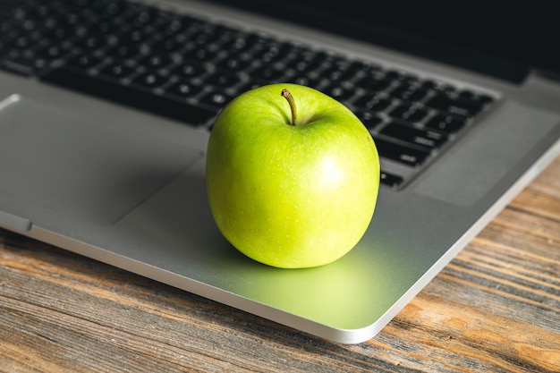 Foto apple vicino al computer portatile al posto di lavoro spuntino sano