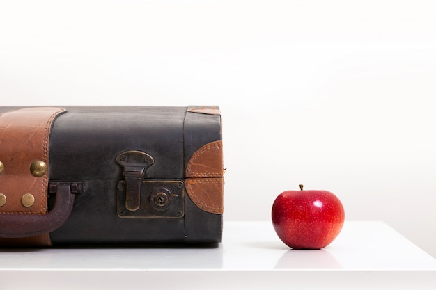 Apple near an old vintage brown suitcase