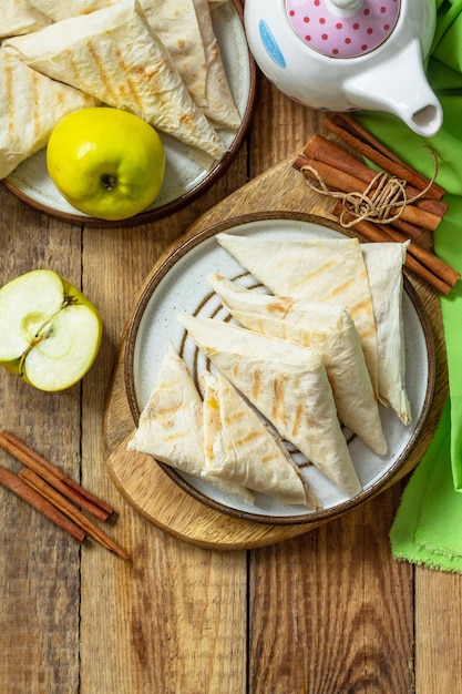 Apple pastries for breakfast Grilled lavash triangle with apples and cinnamon Top view Copy space