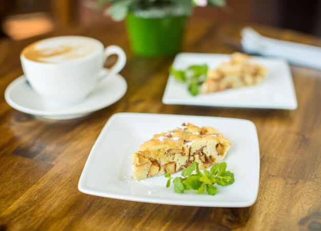 Apple pie and cappuccino on a wooden table