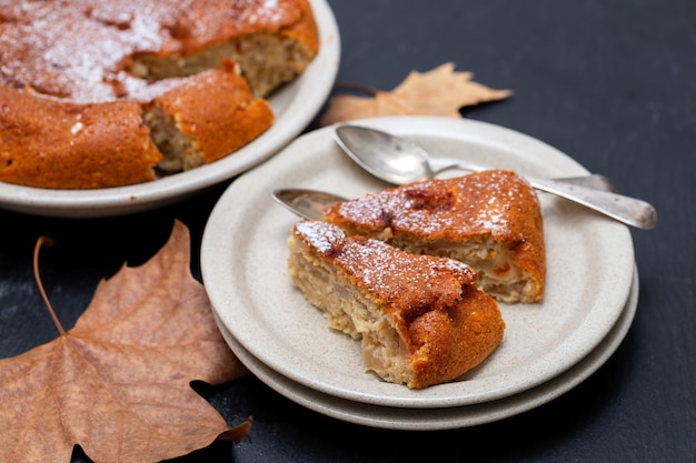 Apple pie on dish on black ceramic surface