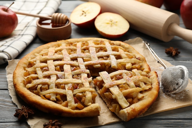 Torta di mele e ingredienti su fondo di legno