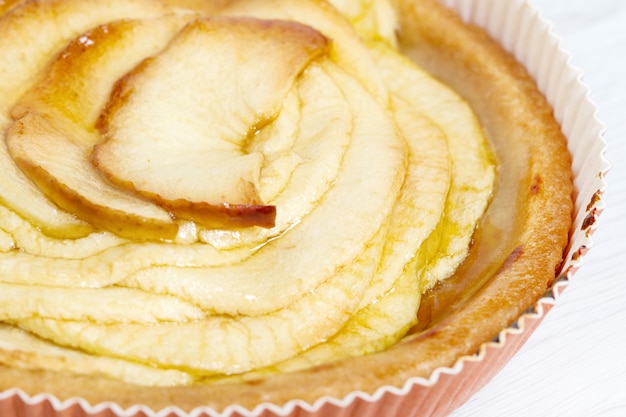 Apple pie on white wood surface