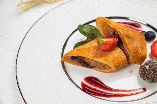 Apple pie with berries on a white table