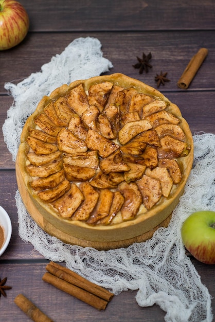 Apple pie with cinnamon on wooden and white napkin