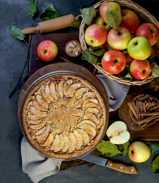 Apple pie with fresh fruits on a wooden table