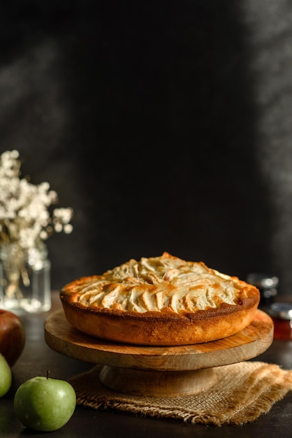 Apple pie with fresh fruits on a wooden table