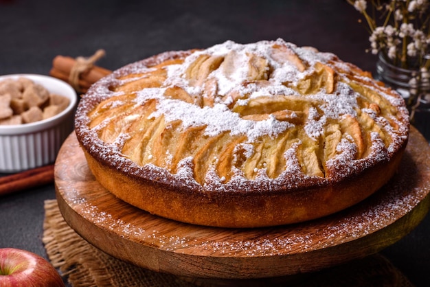 Apple pie with fresh fruits on a wooden table