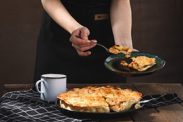 Apple pie with milk on a wooden surface. Rustic style.