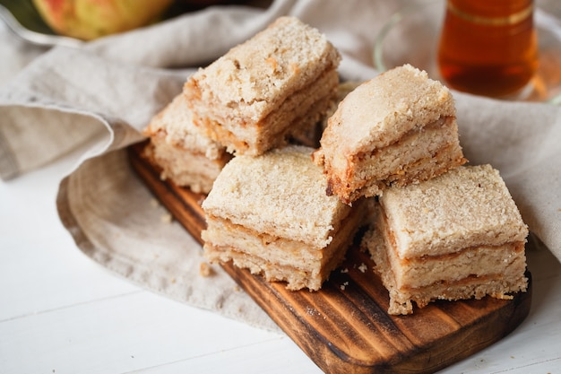 Apple pie on wooden board with tea in beige tones