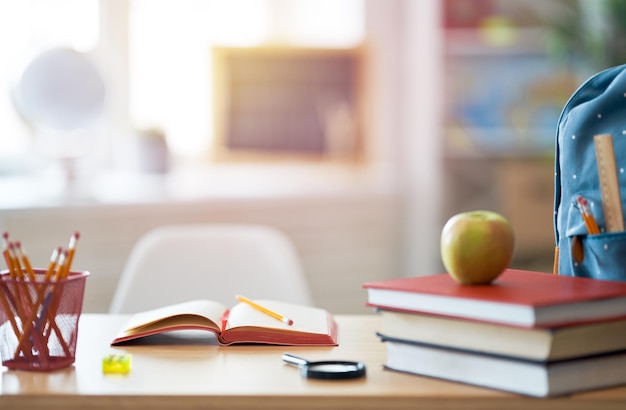 Apple pile of books and backpack