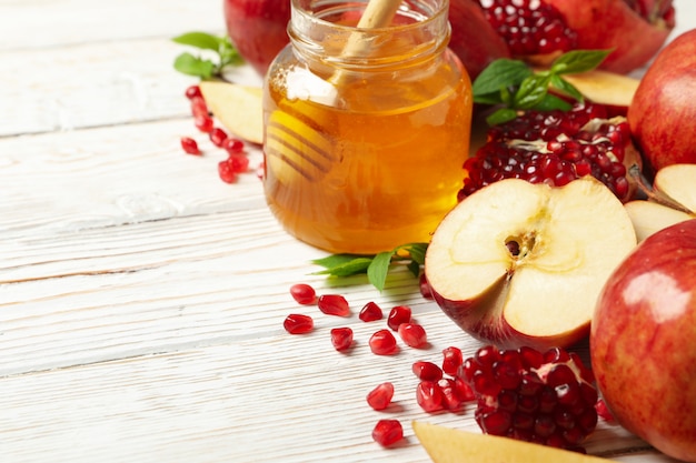 Apple, pomegranate and honey on wooden, close up