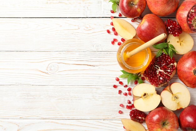 Apple, pomegranate and honey on wooden, top view