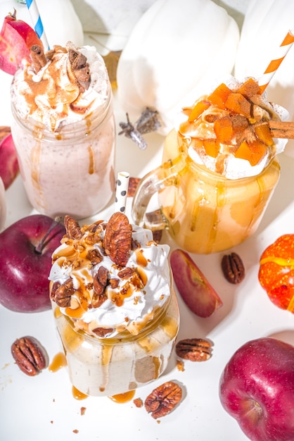 Apple, pumpkin and pecan pie smoothie drinks. Traditional autumn baking cake flavor cocktails set, on white background copy space