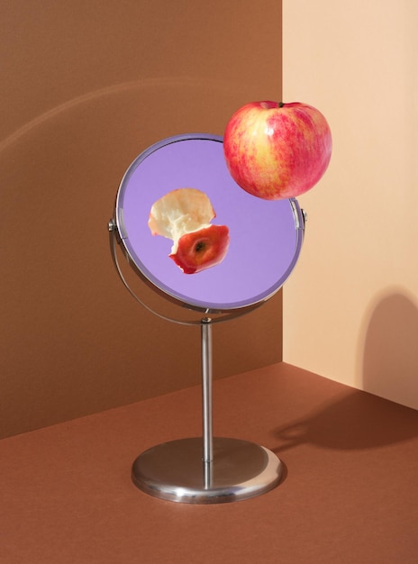 Apple reflected in mirror in the form of stub. Reality and Illusion. Minimalistic psychological composition.