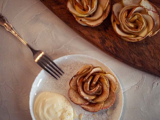 Apple roses apple buns serving with whipped cream and almond petals