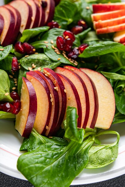 apple salad, green mix lettuce, pomegranate grain healthy meal food snack on the table copy space